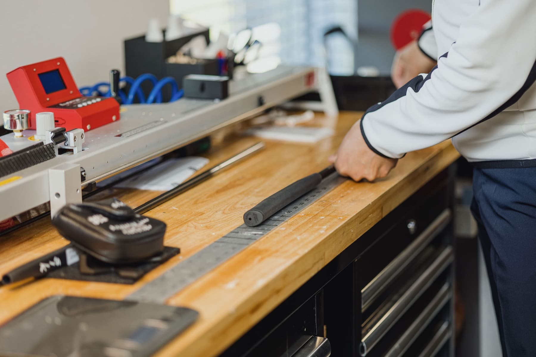 Raymond examines a player's putter at the workbench